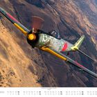 SEPTEMBER-Kalender mit Bild eines historischen Kampfflugzeugs, das über eine bergige Landschaft fliegt.