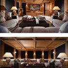 Text: "LES GETS".  
Ein gemütliches Wohnzimmer aus Holz mit Sofas, Kamin, Lampen und Bartisch.