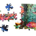 Eine teilweise zusammengesetzte Unterwasser-Illustration mit bunten Fischen und Korallen, auf Puzzleteilen verteilt.