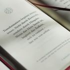 „Transformation beginnt immer innen. Nicht durch Kontrolle, sondern durch Hingabe.“ Offenes Buch, schlichtes Design.