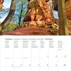 Kalenderseite Oktober; Foto zeigt hohe Felsen und Bäume mit Herbstlaub unter blauem Himmel.