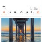 "Mai, KW 20: 17 Montag, Pfingstmontag. Kalenderblatt mit Perspektive unter einem Steg am Meer bei Sonnenuntergang."