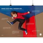 „KRIEG DICH MAL WIEDER EIN...“ Ein Kind in rotem Pullover, dynamisch springend vor einer Wand in Blau und Rot.