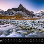"Val d'Hérens im Wallis [Schweiz], Alpen 09." Ein Fluss fließt über Steine, umgeben von herbstlichem Laub und Bergen.