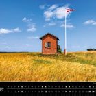 "Dänemark 09" unten links. Ein rotes Ziegelgebäude in einem Feld, daneben weht die dänische Flagge an einem hohen Mast.