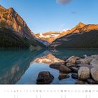 "Morgenruhe am Lake Louise (Alberta) – ein Moment voller Magie." Ein See, umgeben von Bergen, Spiegelung im Wasser, Steine am Ufer.
