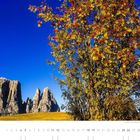 „Ein klarer Herbsttag auf der Seiser Alm mit Blick zum Schlern.“ Kalenderblatt September, herbstlicher Baum, Berglandschaft.