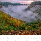 09 – Kalenderansicht. Herbstliche Landschaft mit bunten Bäumen und Nebel in einer Schlucht. Sonnenaufgang hinter Hügeln.