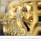 Kalenderseite für September, zeigt verschwommene Nahaufnahme von Goldblasinstrumentenventilen, edle und glänzende Optik.
