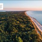 Kurische Nehrung: Strand und dichter Wald am Wasser bei Sonnenuntergang, ruhige Wellen, sandige Küste, üppiges Grün.