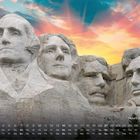 Text: "Mount Rushmore 11". Vier riesige Präsidentenköpfe sind in Fels gehauen, begleitet von einem malerischen Sonnenuntergang.
