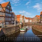 Alter Hansehafen, Stade. Eindruck von Fachwerkhäusern an einem Kanal mit Segelboot, umgeben von roten Ziegeldächern.
