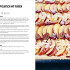 Apfeltaschi mit Trauben. Zutaten und Zubereitung eines Rezepts. Abgebildet sind Apfelspalten, Trauben und Mandeln auf Teig.