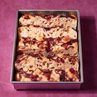 Keine Texte vorhanden. In einer rechteckigen Form liegen mehrere Focaccia-Scheiben mit roten Zwiebeln auf lila Untergrund.