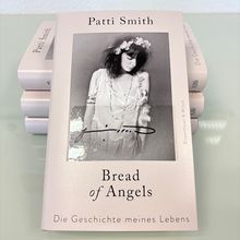 "Patti Smith, Bread of Angels, Die Geschichte meines Lebens." Buchcover mit Foto einer Frau in weißem Kleid und Blütenkranz.