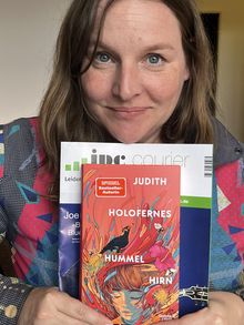 "JUDITH HOLOFERNES HUMMEL HIRN" steht auf dem farbenfrohen Buchcover, gehalten von einer Frau.