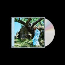 Ein CD-Cover zeigt eine Person in einem fließenden, hellblauen Kleid vor einem großen, alten Baum auf einer grünen Wiese.