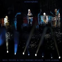 "As time explodes", "Neil Young & The Chrome Hearts Live Album". Dunkle Bühne mit bunten Lichtern und Musiker-Silhouetten.