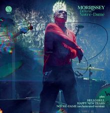 "Morrissey, Deluxe, Notre-Dame, plus, Hello Hell, Happy New Tears, Notre-Dame (orchestrated version)". Ein Mann in roter Kleidung steht auf einer Bühne.