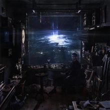 Es gibt keine sichtbaren Texte. Eine Person sitzt in einem Raum mit Blick auf einen leuchtenden Planeten oder eine Sphäre.