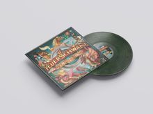 Text: "FEUERSCHWANZ SEX IS MUSS". Cover mit Fantasiefiguren wie Drachen und einem Ritter; daneben eine grüne Vinyl-Schallplatte.