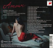 "Amour" ist prominent zu sehen. Darunter stehen Namen wie Esther Abrami und Titel von Musikstücken. Eine Frau in rotem Kleid sitzt rückwärts auf einer Couch. 