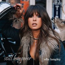 „Still hungover“ und „ella langley“ in eleganter Schrift. Frau mit langen Haaren, Pelzjacke, Hand am Auto.