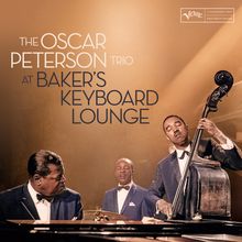 "The Oscar Peterson Trio at Baker’s Keyboard Lounge." Drei Musiker in Anzügen spielen Klavier, Bass und Schlagzeug.