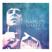 "RAMSES SHAFFY laat me" steht neben einem Mann mit Mikrofon im Retro-Stil. Hintergrund ist blau und texturiert.