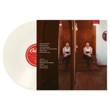 Text: "Niall Horan Dinner Party". Eine Person trinkt aus einer Tasse in einer rustikalen Küche mit Geschirr an den Wänden und einem Fenster.