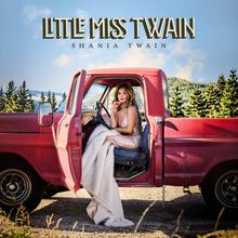 Oben steht "Little Miss Twain" und darunter "Shania Twain". Eine Frau sitzt in einem roten, offenen Oldtimer-Truck.