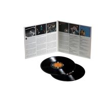 Zu sehen sind Textabschnitte und Fotos in einer geöffneten Plattencoverhülle, einschließlich zwei schwarzer Vinyl-Schallplatten.