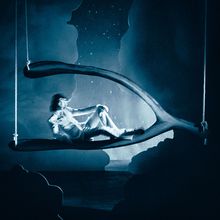 Eine Person sitzt entspannt in einem übergroßen Wishbone-Objekt, umgeben von einer traumhaften, sternennächtlichen Szene.