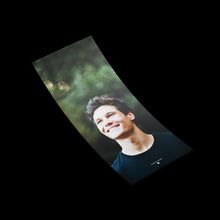 Ein lächelnder junger Mann vor einer verschwommenen grünen Kulisse. Text: "Made in Switzerland".