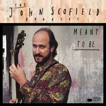 "The John Scofield Quartet Meant to Be" zeigt einen Mann mit Gitarre vor einer verwitterten Wand, trägt ein buntes Hemd.