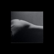 Ein Schwarz-Weiß-Foto zeigt die Rückseite eines Körpers in einem sanften Licht- und Schattenspiel.