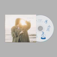 Text: "singing", "gia margaret is singing".  
Eine Frau hält die Hand vor das Gesicht im Sonnenlicht, mit Hintergrund Meer und Himmel. CD rechts mit blauen Illustrationen.