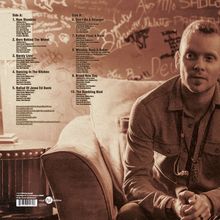 Die Trackliste enthält Titel wie "Run Stumblin'", "Barely Livin'", und "Brand New Day". Rechts daneben sitzt ein Mann auf einem Sofa.