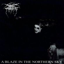 "A Blaze in the Northern Sky" unten. Schwarz-weißes Bild einer Gestalt mit weiß geschminktem Gesicht, düsterer Atmosphäre.
