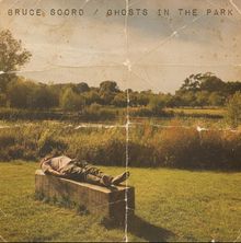"BRUCE SOORD / GHOSTS IN THE PARK." Eine Person liegt entspannt auf einer Bank in einer sonnigen Parklandschaft.