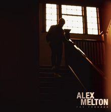 Text: "ALEX MELTON THE PROCESS." Eine dunkle, beleuchtete Treppe mit einer Person im Hintergrund vor einem Fenster.