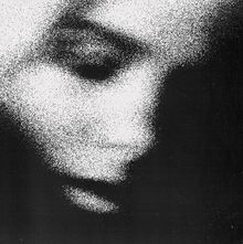 Ein abstraktes, körniges Porträt eines Gesichts, schwarz-weiß gehalten, vermittelt Dunkelheit und Geheimnis.
