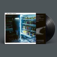 Text: "FOR WARDS WEIGHT" und "THE BELGIAN BLUE". Kühlschrankregal mit Getränkeflaschen, Vinyl-Schallplatte im Hintergrund.