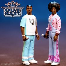 "OUTKAST"-Logo mit Krone, zwei Figuren: links in hellblau-weißem Outfit, rechts in farbenfrohen Schlaghosen.