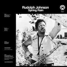 "Rudolph Johnson Spring Rain" und "Players" texten links. Mann mit Saxofon hebt Arm. Im Hintergrund Bäume.