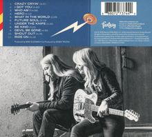 Text oben: Trackliste mit 11 Titeln. Unten: Schwarz-weiß Bild von zwei Personen mit Gitarren. Links sitzt ein Mann, rechts eine Frau.