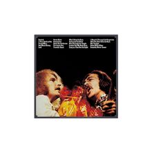 Texte: „Suzie Q, I Put a Spell on You, Proud Mary“ usw. Zwei Männer singen leidenschaftlich, einer mit Brille, beide sind in warmem Licht.