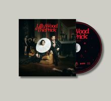 "Lilly Wood & The Prick" in roten Buchstaben. Eine elegante Frau mit großem Kragen und ein Mann in Anzug sitzen auf einem Sofa.