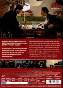 NYAFF präsentiert beim NEW YORK ASIAN FILM FESTIVAL. Zwei Männer sitzen an einem Tisch, eine helle Lampe leuchtet.