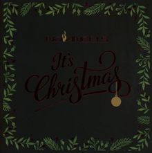 "No Angels It's Christmas" in festlicher Schrift, umgeben von einem Kranz aus grünen Blättern und roten Beeren.